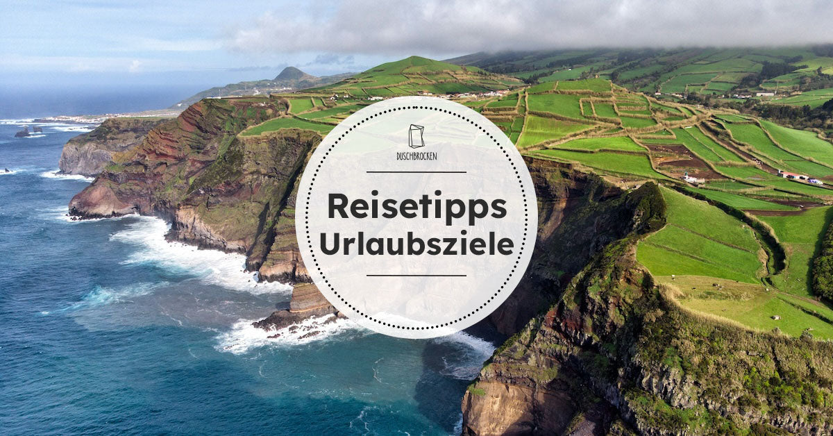 Drohnenperspektive auf die Küste der Azoren mit Wasser, Klippen und Feldern 