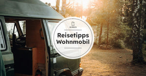 Campervan steht in der Lichtung eines Waldes und die Schiebetüre ist offen