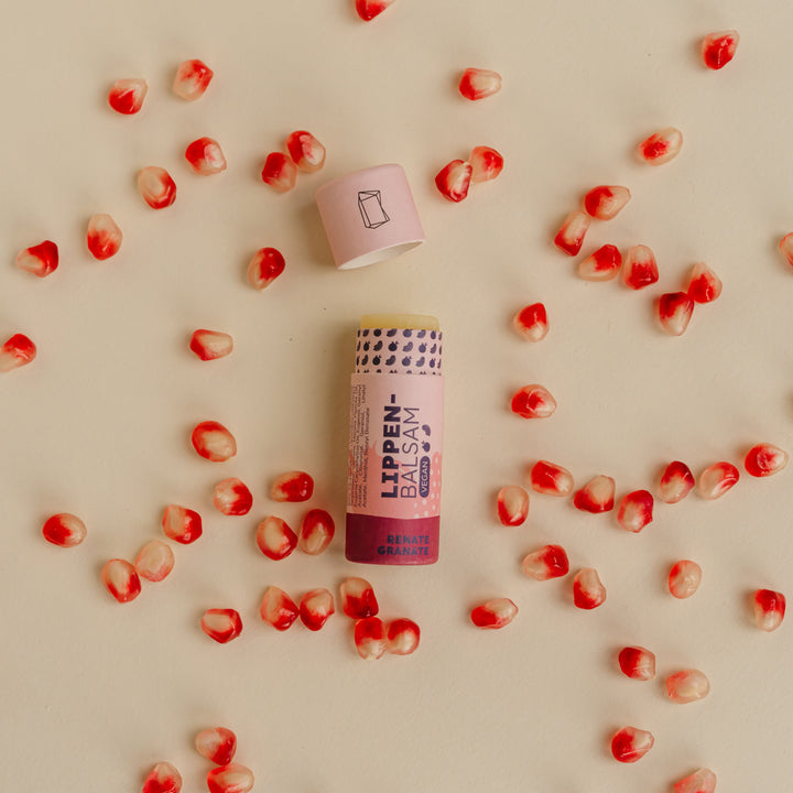 Renate Granatapfel Lippenbalsam flatlay mit Granatapfelkernen
