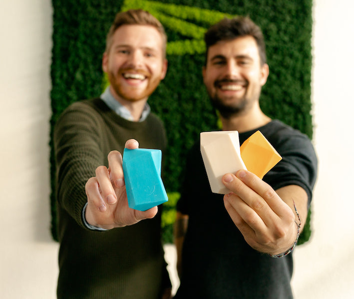 Johannes und Christoph halten Duschbrocken in die Kamera und lachen